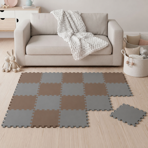 Ein Steckpuzzlespielteppich für Kinder in einem Wohnzimmer, zusammengesetzt aus quadratischen Schaumstoffelementen in zwei verschiedenen Tönen.