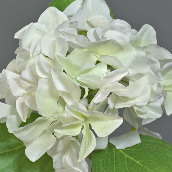 Detailansicht eines künstlichen Hortensienblattes mit gezacktem Rand und weißen Textilblütenblättern.