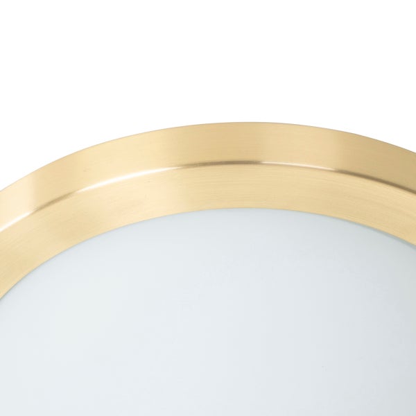 Nahaufnahme einer runden Deckenleuchte mit Rahmen aus gebürstetem Metall in Gold und weißem Diffusor.