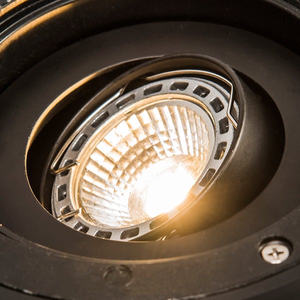 Nahaufnahme eines Einbaustrahlers mit schwarzem Gehäuse und leuchtendem LED Leuchtmittel mit Facettenreflektor.