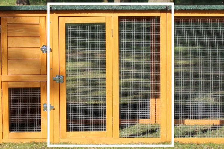 Detailansicht eines Kleintierstalls aus Holz mit Gittertüren und Metallriegeln.