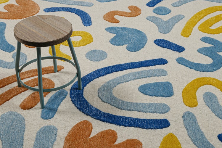 Teppich mit abstrakten blauen, orangen und gelben Formen, darauf ein runder Holzhocker mit Metallbeinen.