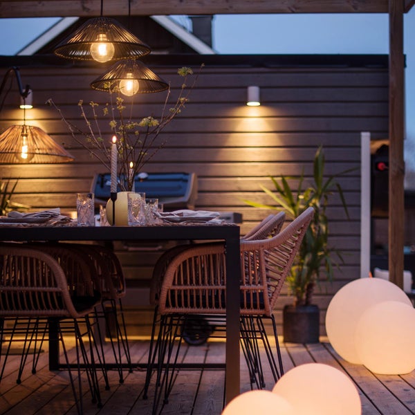 Dekoration mit zwei Lichterketten und Tannenzapfen auf einem Tisch