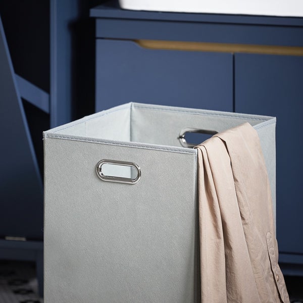 Grauer Stoff-Faltkorb mit Metallgriffen vor blauem Schrank