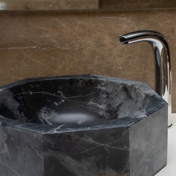 Achteckiges Aufsatzwaschbecken aus Naturstein mit verchromter Waschtischarmatur in einem modernen Badezimmer.