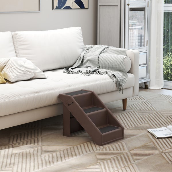Dreistufige Tiertreppe aus Kunststoff neben einem weißen Sofa in einem hellen, modern eingerichteten Wohnzimmer. PawHut Logo ist sichtbar.