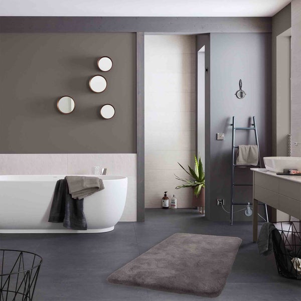 Modernes Badezimmer mit Badewanne, Spiegeln, Handtuchwärmer und Teppich
