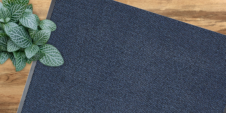 Fußmatte mit Pflanzenmuster auf Holzboden