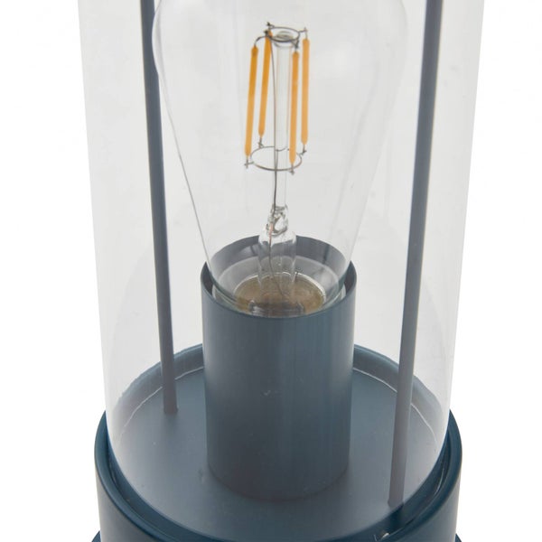 Nahaufnahme einer LED-Filament-Glühbirne in einer zylindrischen Leuchte mit klarem Glaszylinder und dunkelblauem Gehäuse.