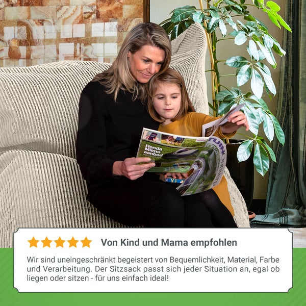 Eine Frau und ein Kind sitzen auf einem Sitzsack und lesen eine Zeitschrift.
