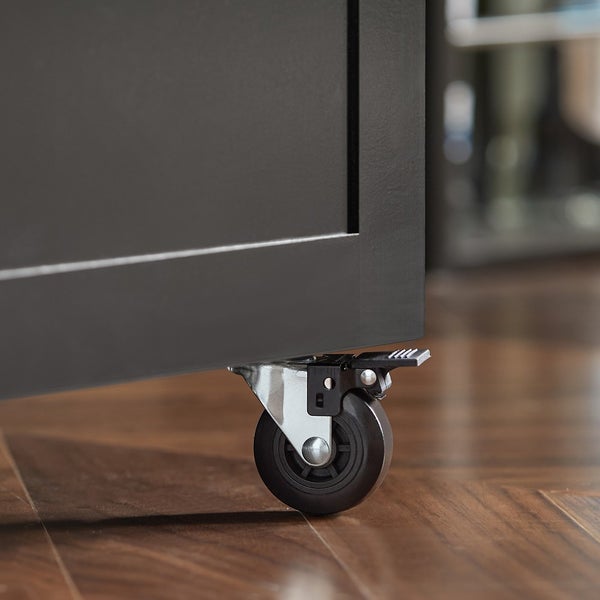 Detailansicht eines Möbels mit Rollen und Feststellbremse auf einem Holzboden