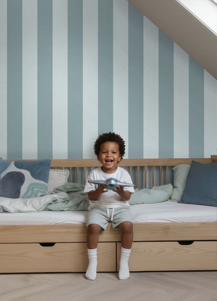 Gestreifte Tapete mit vertikalen Streifen in einem hellen Kinderzimmer mit Holzbett und Parkettboden.