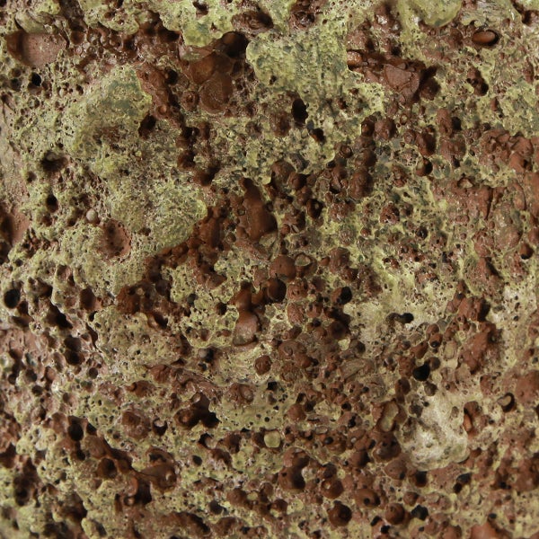 Nahaufnahme der porösen und rauen Oberflächenstruktur eines Lavasteins.