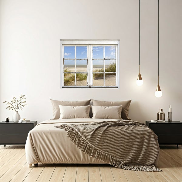 Schlafzimmer mit Bett, Nachttischen und Dekorationsartikeln. Das Fenster zeigt einen Strand.