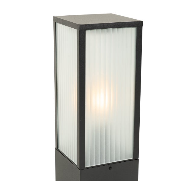 Moderne rechteckige Außen-Sockelleuchte mit schwarzem Metallrahmen und satiniertem, geriffeltem Glas, beleuchtet.
