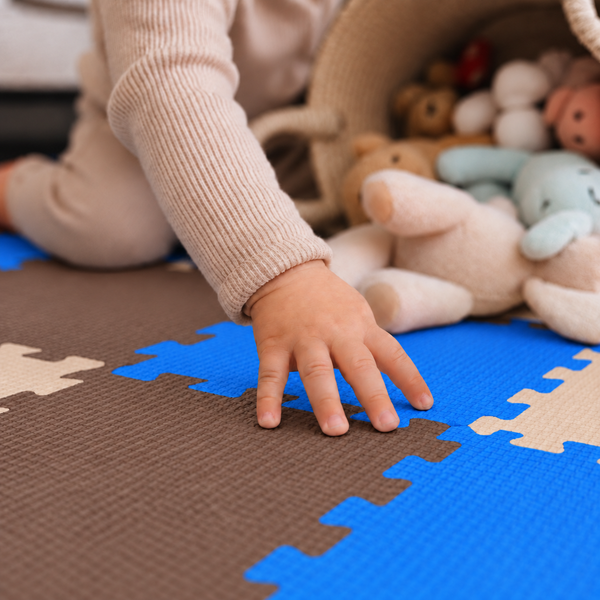 Kind spielt auf einer Puzzlematte aus Schaumstoff mit Spielzeug