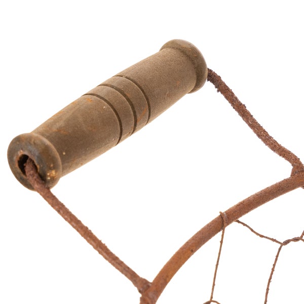 Nahaufnahme eines rustikalen Holzgriffs mit Einkerbungen an einem rostigen Metallgestell.