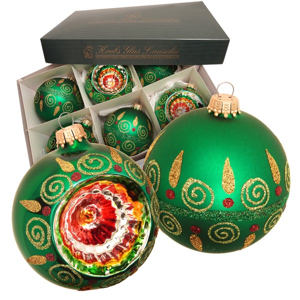 Dekorative grüne Weihnachtskugeln mit goldenen Verzierungen in einer Geschenkbox