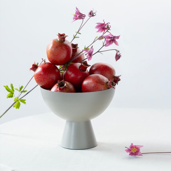 Dekorative Schale mit Granatäpfeln und Blütenzweigen