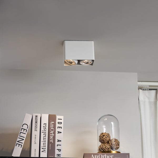 Weiße Deckenleuchte mit zwei Strahlern im Innenraum.