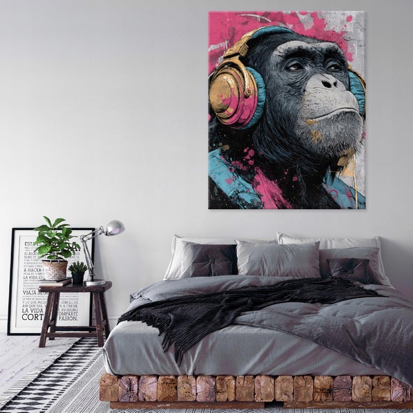 Wandbild mit Affenmotiv mit Kopfhörern über einem Bett in einem modern eingerichteten Schlafzimmer mit Holzbettsockel.