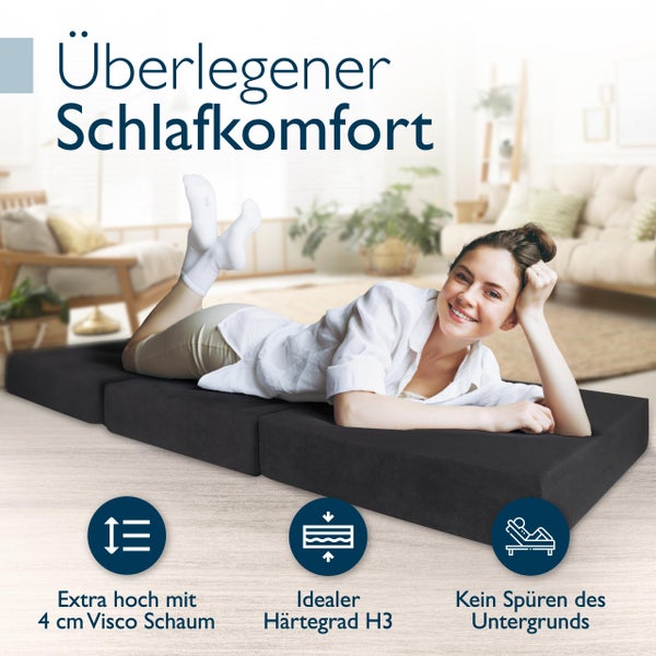 Frau liegt auf einer grauen Gästematratze mit einer Höhe von 4 Zentimetern Viscoschaum und dem Härtegrad H3.