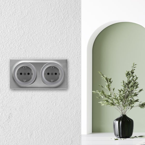 Doppelsteckdose für Unterputzmontage an einer strukturierten Wand in einem modern gestalteten Raum mit Torbogen und Dekopflanze