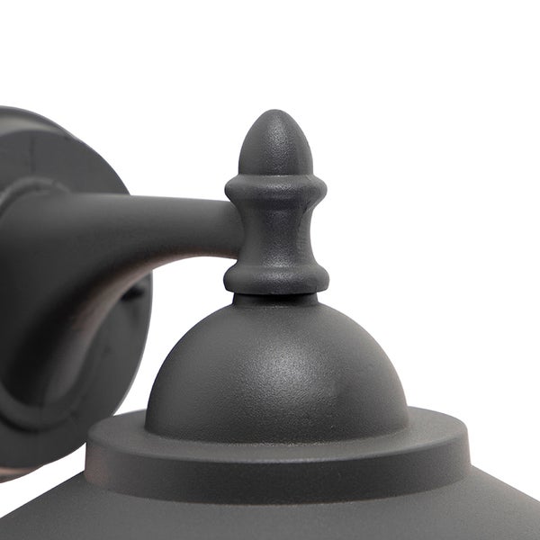 Detailansicht einer Außenwandleuchte aus Metall mit dekorativer Spitze und Wandarm.