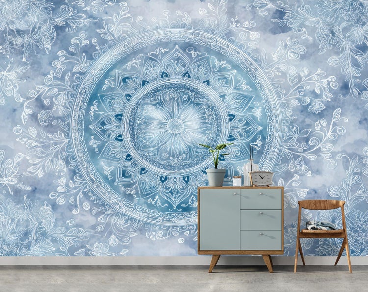 Fototapete mit weißem Mandala-Muster auf blauem Hintergrund in einem Raum mit Kommode und Holzstuhl.
