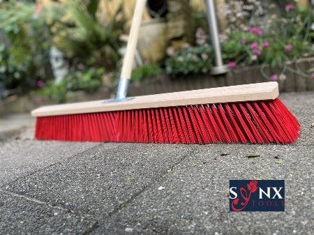 Bürste mit Holzstiel und roten Borsten für Reinigungsarbeiten im Aussenbereich