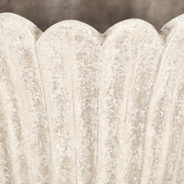 Detailansicht eines Pflanzgefäßes mit vertikalen Rillen und gewelltem Rand in antiker Steinoptik.