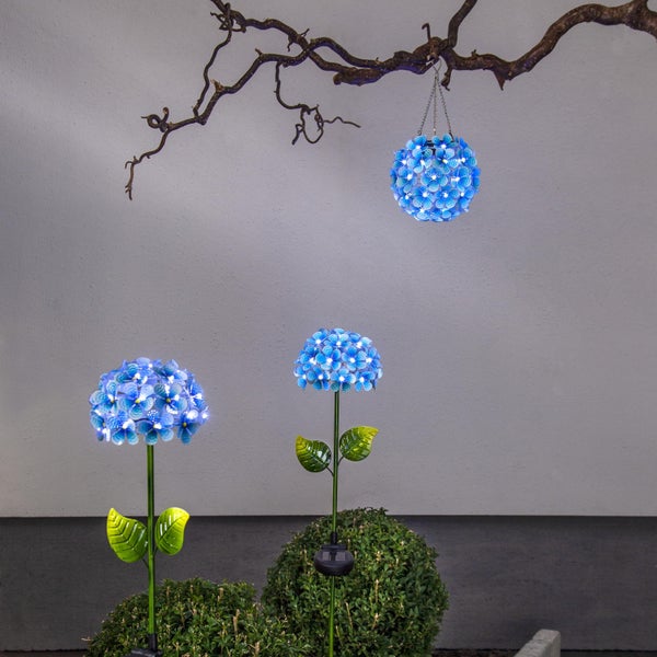 Szene mit zwei Hydrangea Solarsteckleuchten und einer Hydrangea Solarlaterne, die an einem Ast hängt