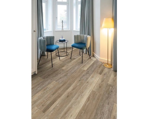 Vinylboden mit Holzstruktur in einem hellen Raum mit zwei Sesseln, einem Beistelltisch und einer Stehlampe.