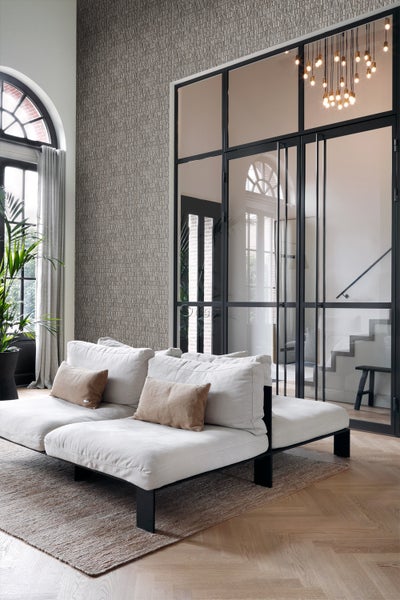 Heller Wohnraum mit Sofa, Teppich und gemusterter Tapete