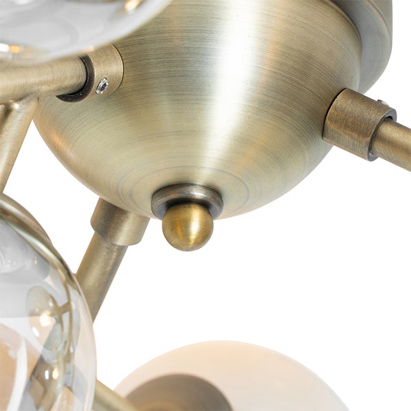 Detailaufnahme einer Deckenleuchte mit Messingbeschichtung und gläsernen Lampenschirmen