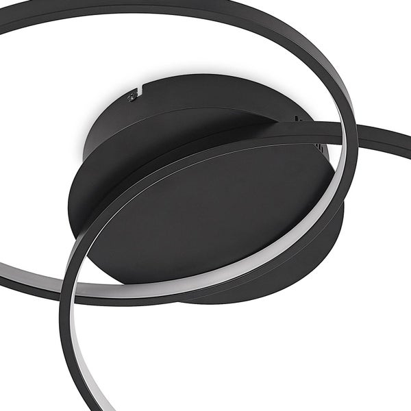 Nahaufnahme einer modernen LED-Deckenleuchte mit rundem schwarzem Sockel und einem geschwungenen Lichtband.