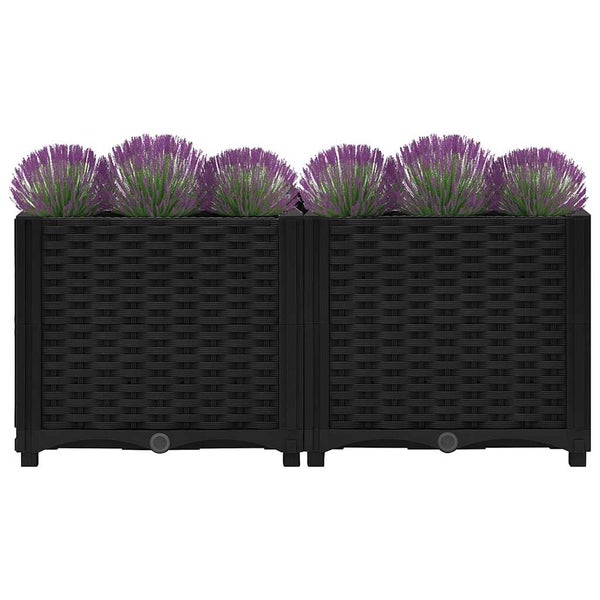 Hochbeet aus schwarzem Polyrattan mit lila Blumen.