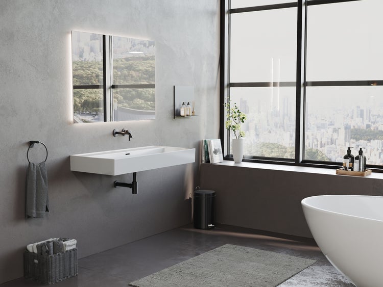 Modernes Badezimmer mit weißem Waschtisch, beleuchtetem Spiegel, freistehender Badewanne und großem Fenster mit Stadtblick.