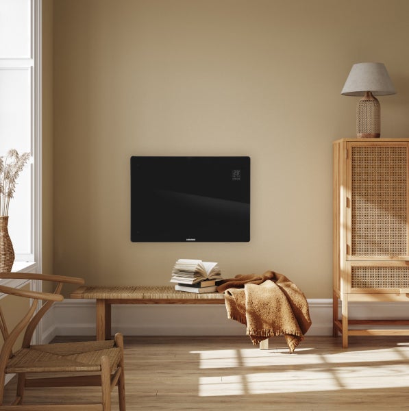 Ein elektrischer Flachheizkörper von Vonroc, montiert an einer Wand in einem modern eingerichteten Wohnraum mit Holzmöbeln und gemütlichem Ambiente.