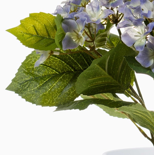 Künstliche Hortensie mit blauen Blüten und grünen Blättern.