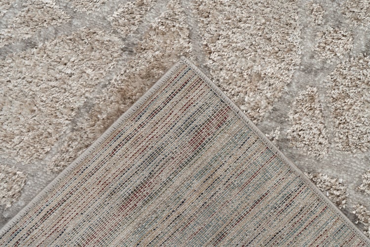 Detailansicht eines Teppichs mit hochflorigem Muster und textiler Rückseite.