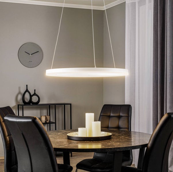 Moderne ringförmige LED Pendelleuchte über rundem Marmoresstisch mit schwarzen Lederstühlen in einem eleganten, hellen Esszimmer.