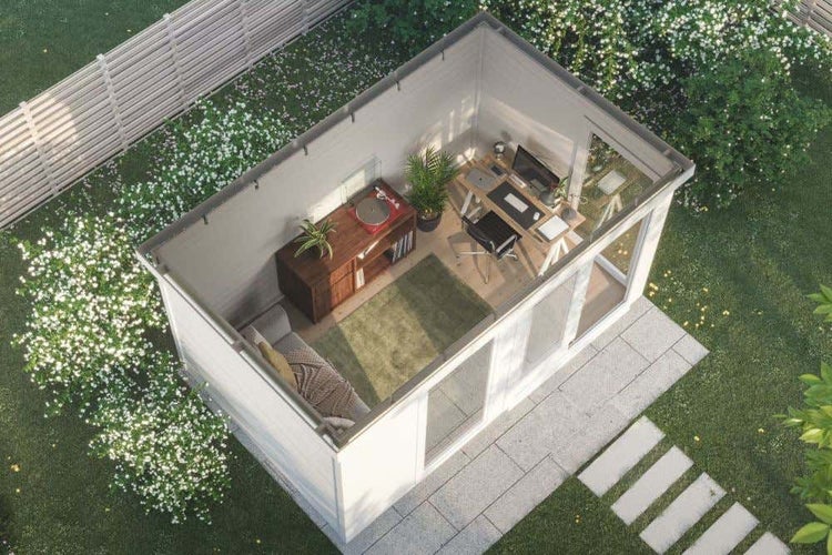 Draufsicht auf ein modernes Gartenhaus als Büro mit Schreibtisch, Sofa und Pflanzen in einem Garten mit blühenden Sträuchern.