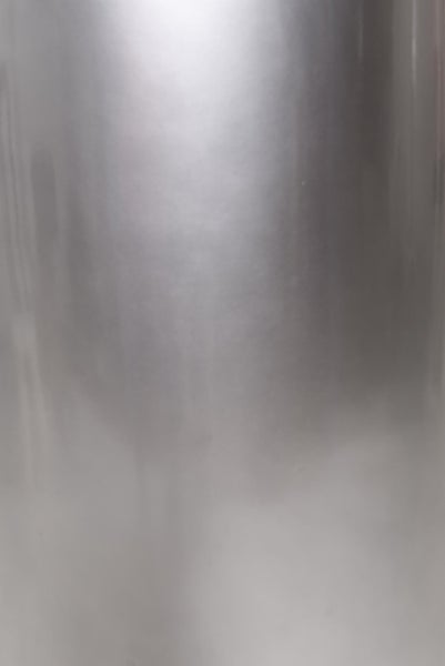 Nahaufnahme einer metallischen Oberfläche mit Lichtreflexion