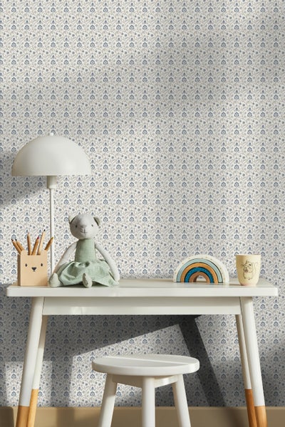 Kinderzimmer mit floral gemusterter Tapete, Schreibtisch, Hocker und Dekoration