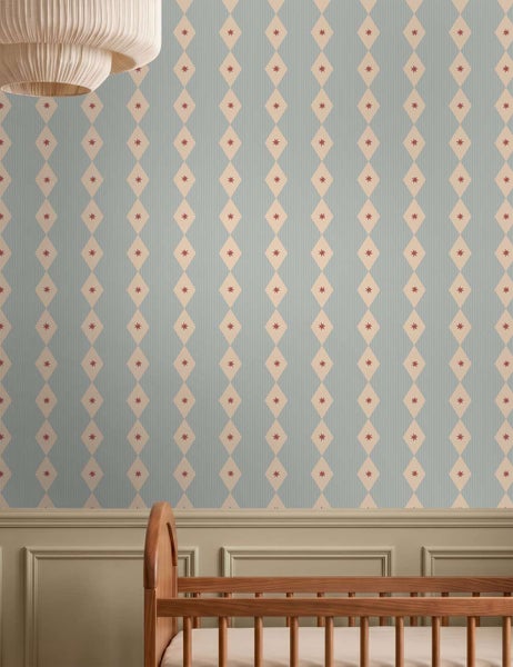 Tapete mit Rautenmuster und kleinen Sternen in einem Kinderzimmer mit Holzgitterbett und Paneelwand.