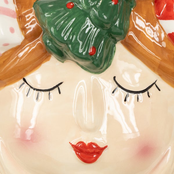 Gesicht einer Keramikfigur mit Weihnachtsmotiv