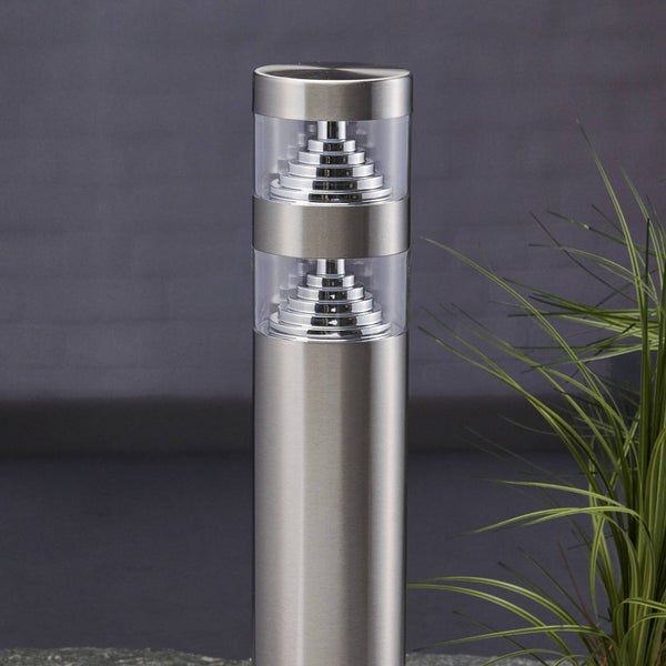 Zylindrische Außenleuchte aus Edelstahl mit zwei transparenten Lichtauslässen und gestuften Reflektoren.