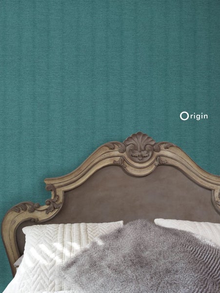 Nahaufnahme einer Wand mit Textiltapete hinter einem Bett