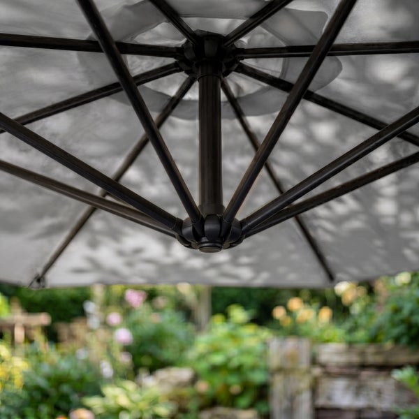 Untersicht eines geöffneten Sonnenschirms mit stabilen Metallstreben und Gestell im Garten.
